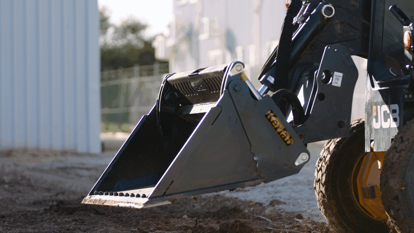skid steer 4 in 1 Kerfab skid steer 4-in-1 bucket working on site with soil load.