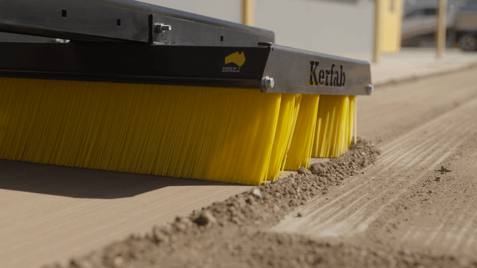9 Kerfab K-Broom push broom on a skid steer sweeping yard debris.